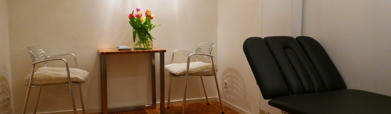 Behandelkamer met twee stoelen en behandelbank